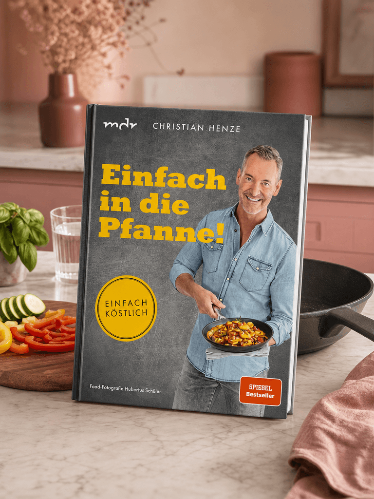 Buch „Einfach in die Pfanne!“ liegt auf einem Holztisch im warmen Licht, Cover voll sichtbar