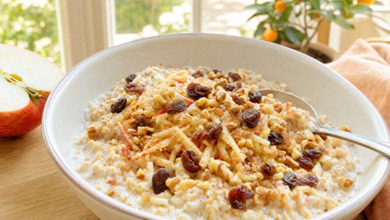 Schale Overnight Oats mit geriebenem Apfel, Zimt, Rosinen und Walnüssen im Wintergarten